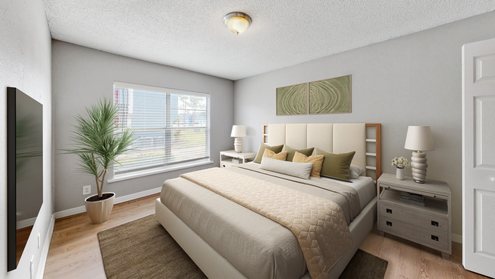 Hard wood style flooring, rug, flat screen TV, king bed with tan bedding, decorative plant, large center window