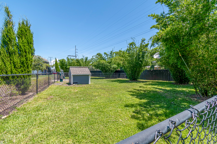 Dog park with lush greenery and a dog house