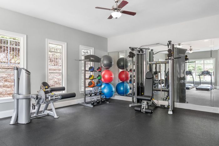 Modern gym with state-of-the-art fitness equipment, bright windows, and colorful exercise balls.