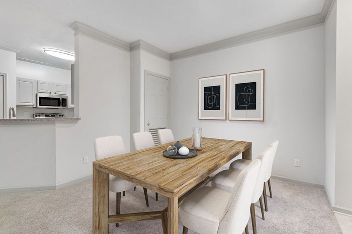 Bright and modern dining area featuring a rustic wooden table, elegant chairs, and minimalist artwork.