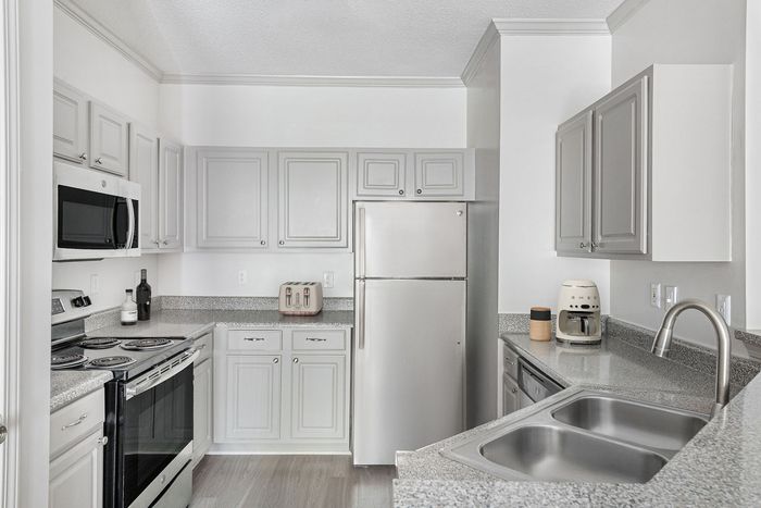 Elegant kitchen with modern appliances, sleek countertops, and ample storage in chic cabinetry.