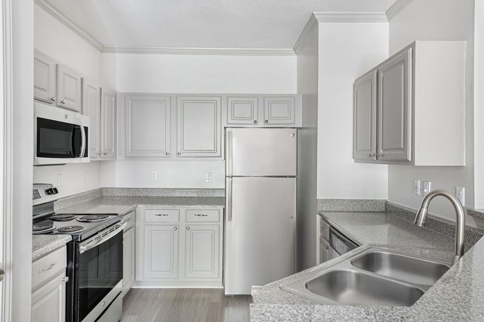 Modern and bright kitchen with sleek stainless steel appliances, ample cabinetry, and elegant countertops, perfect for culinary creativity.