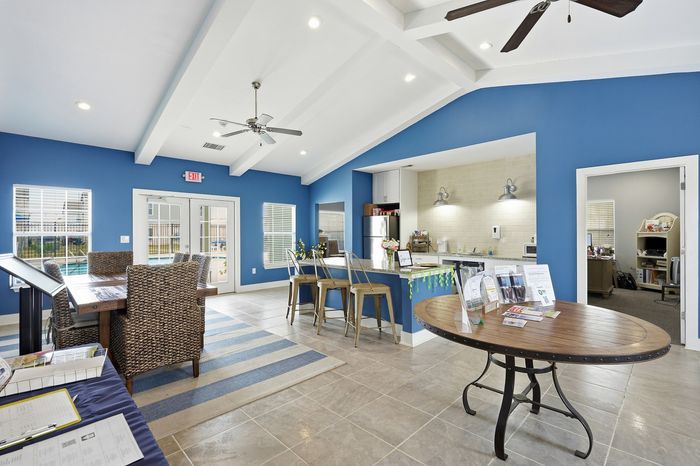 Spacious clubhouse with a comfortable sofa, beautiful area rug, and entertainment center at Portside Villas, Ingleside, TX