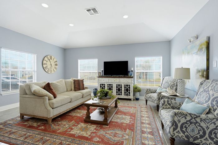 Spacious clubhouse with a comfortable sofa, beautiful area rug, and entertainment center at Portside Villas, Ingleside, TX