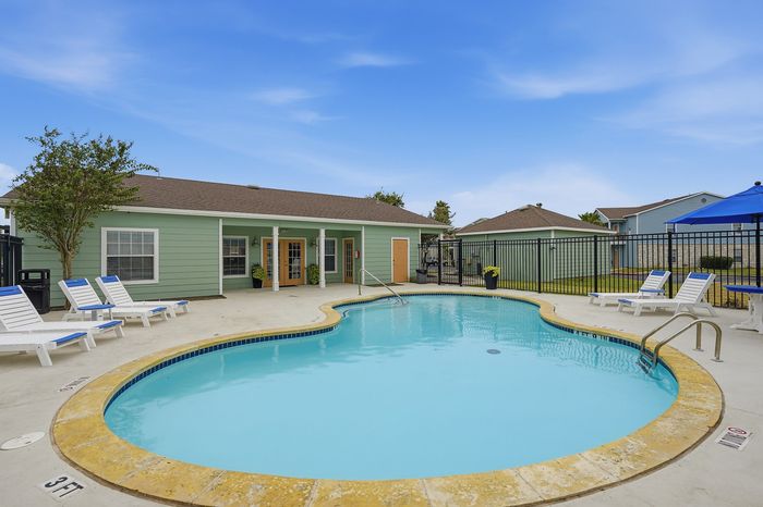 Sparkling lounge pool surrounded by comfortable seating and lush greenery at Portside Villas, Ingleside, TX