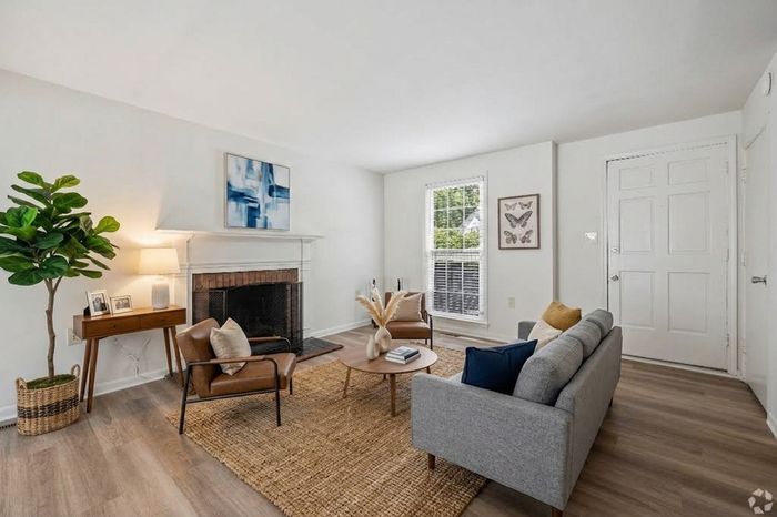 Elegant living room with a cozy fireplace, modern furnishings, and abundant natural light, perfect for relaxing and entertaining.