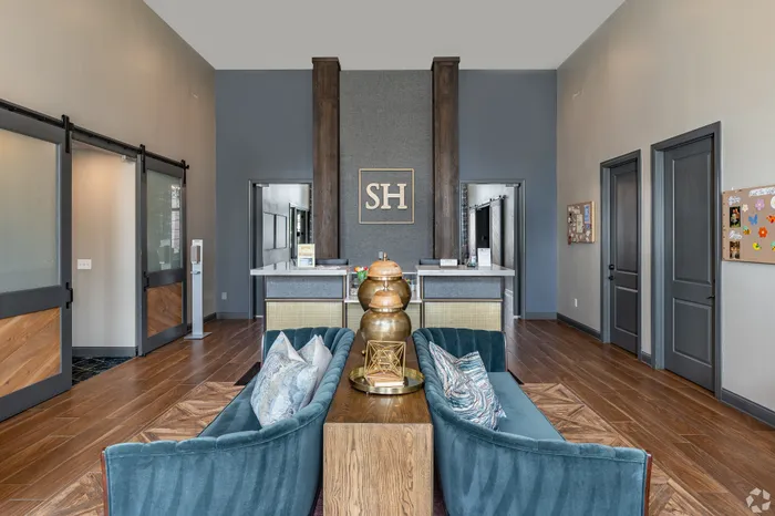 Modern, elegant lobby with plush seating, wooden accents, and stylish decor. Featuring sleek sliding doors and a tasteful reception area.