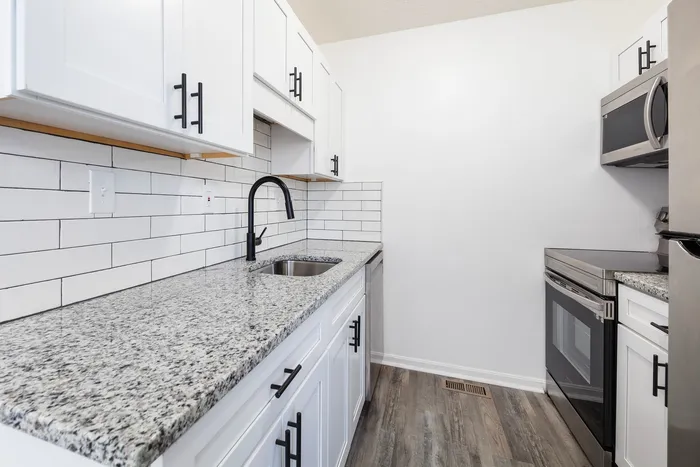 Renovated kitchen with granite countertops and stainless steel appliances