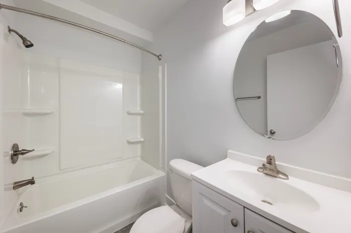 Large bathroom with stainless steel finishes, contemporary lighting, and a spacious shower with tub.