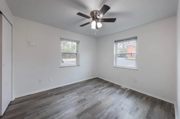 Spacious Bedroom with ceiling fan, large windows, and en suite closet.