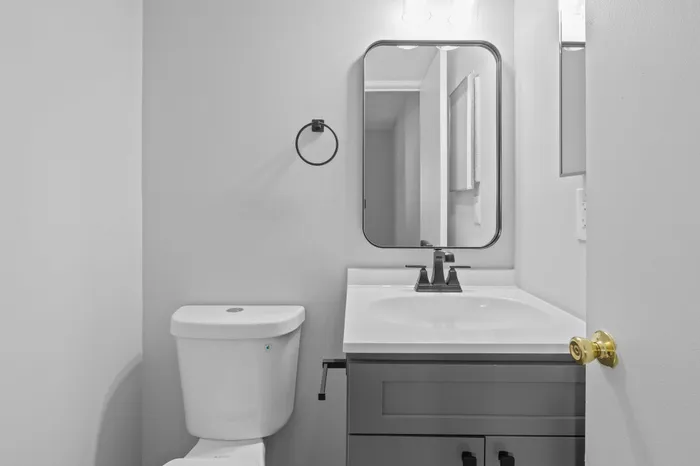 Chic modern bathroom with elegant fixtures, a sleek vanity, and sophisticated black accents.