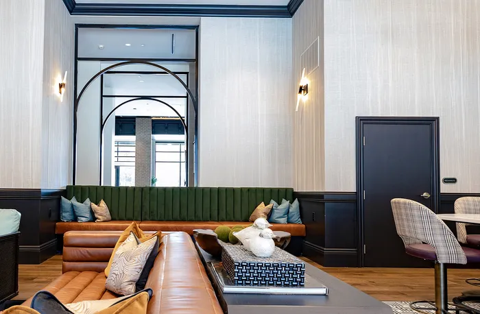 Chic and modern living room with plush leather seating, elegant wall design, and decorative cushions, creating a cozy and inviting atmosphere.