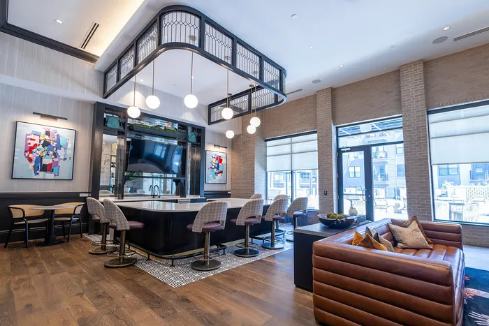 Luxurious contemporary lounge with chic bar seating, modern art, and ample natural light.