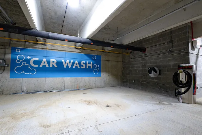 Modern and spacious indoor car wash facility with high ceilings and professional equipment.