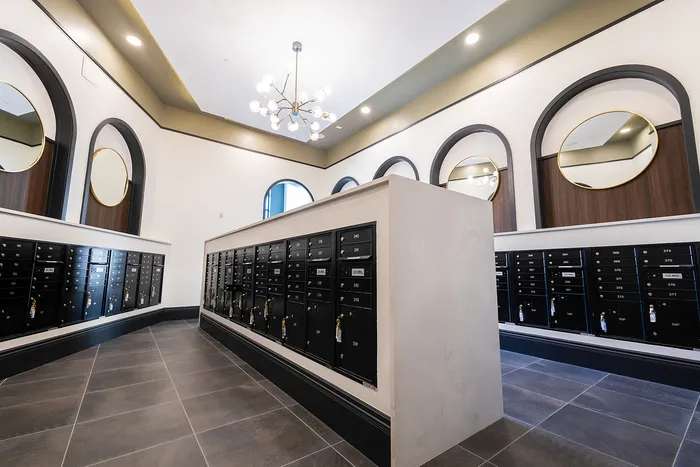 Elegant mailroom with sleek black mailboxes, modern lighting, and chic circular mirrors, creating a stylish and functional space.
