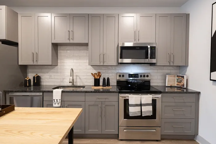 Modern kitchen with sleek gray cabinetry, stainless steel appliances, and a chic backsplash, perfect for gourmet cooking.