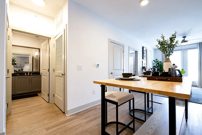 Chic and modern apartment interior featuring an open kitchen with a stylish wooden island, elegant dining setup, and bright living area with contemporary decor.