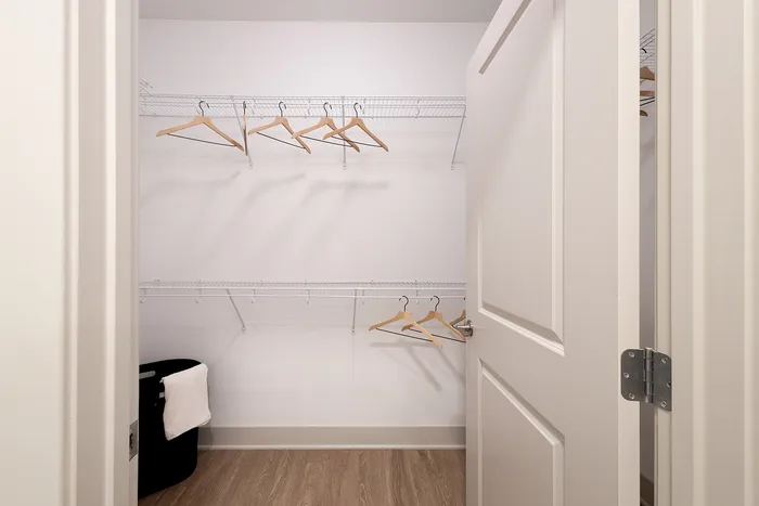 Spacious walk-in closet with modern shelving and ample hanging space, perfect for organized storage.