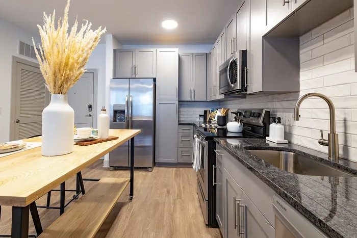 Modern kitchen with sleek gray cabinets, stainless steel appliances, and a stylish wood island, perfect for contemporary living.