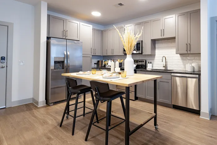 Modern kitchen with sleek grey cabinetry, stainless steel appliances, and a stylish island with seating.