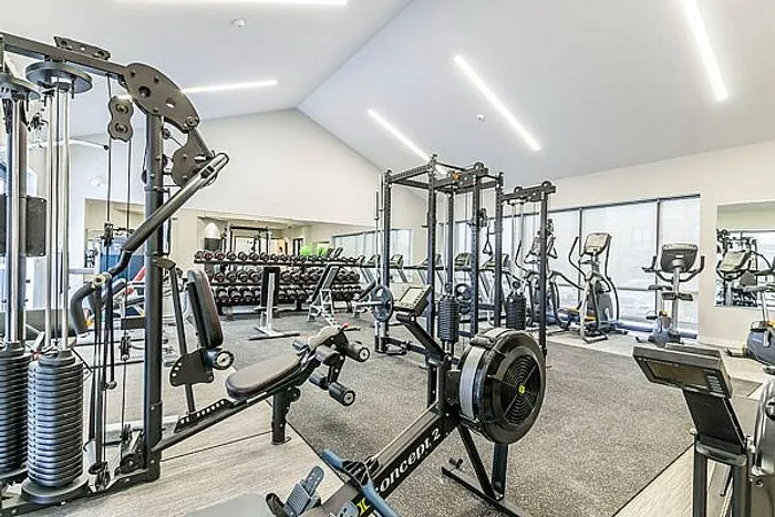 Modern fitness center featuring state-of-the-art exercise equipment, bright lighting, and spacious layout for an invigorating workout experience.