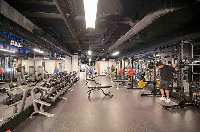Modern gym with state-of-the-art equipment, complete with weight racks, cardio machines, and a spacious workout area.