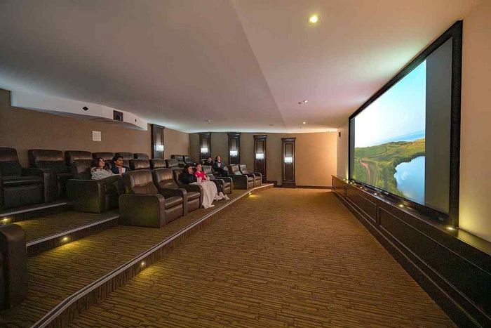 Elegant home theater with luxurious recliner seating and a large screen for an immersive cinematic experience.