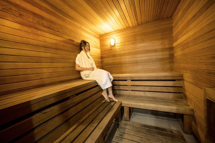 Luxurious wooden sauna with a warm ambiance, featuring comfortable seating and soft lighting for ultimate relaxation.