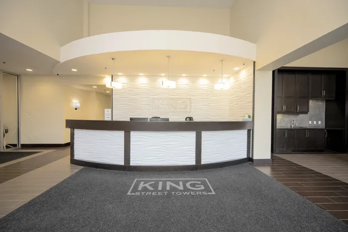 Elegant and modern reception area at King Street Towers with a sleek, curved desk and ambient lighting.