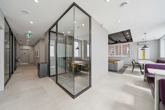 Modern apartment interior featuring sleek glass walls, cozy seating areas, and stylish lighting, offering a blend of comfort and sophistication.