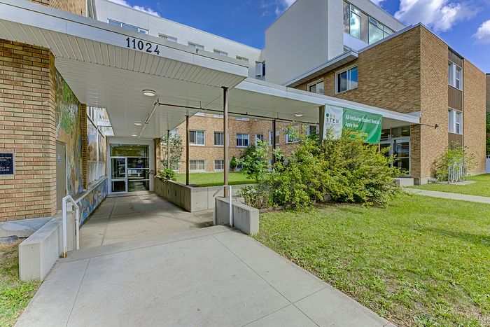 Inviting entrance to a modern student rental building with a well-maintained garden and bright exterior.