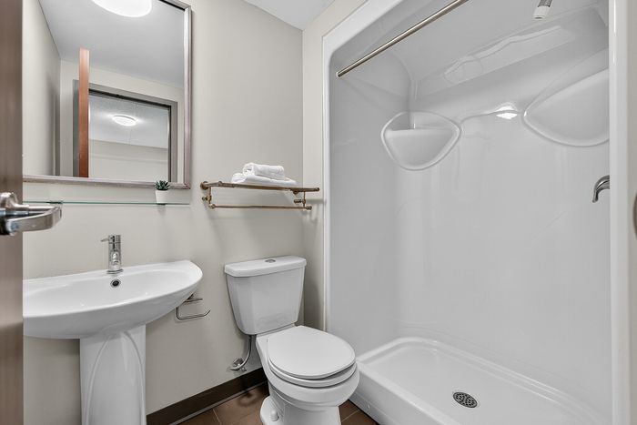 Contemporary bathroom design showcasing a sleek pedestal sink, modern toilet, and spacious shower, perfect for luxury living.