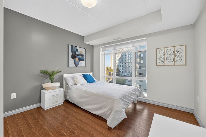 Bright and modern bedroom with large windows, stylish decor, and city view, perfect for urban living.