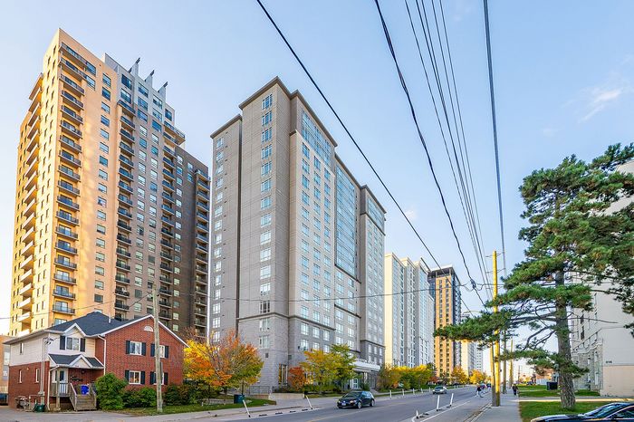 Vibrant urban scene featuring modern high-rise apartments with large windows, nestled on a tree-lined street, creating an ideal city living experience.