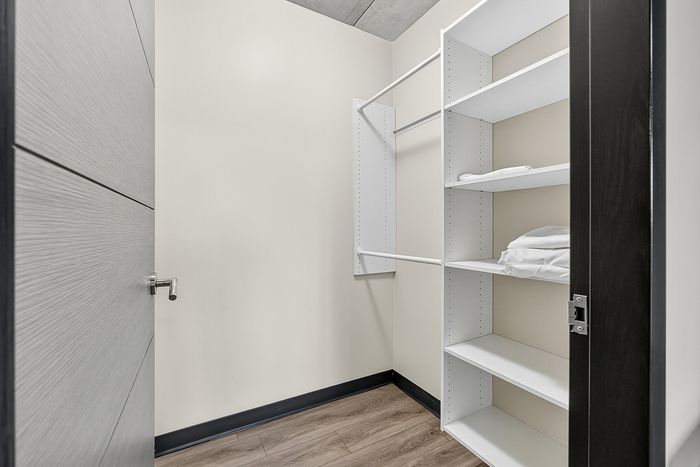 Chic walk-in closet with sleek shelving and modern storage solutions, highlighting contemporary apartment amenities.