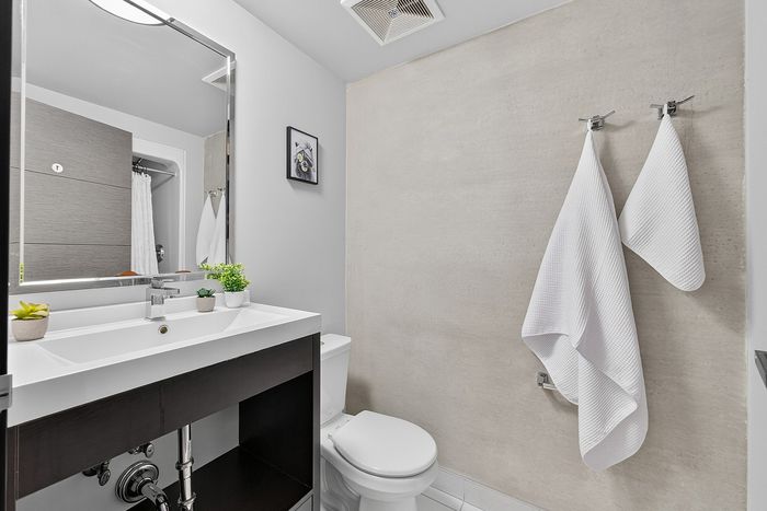 Sleek modern bathroom with elegant white fixtures, a stylish vanity, and bright d&eacute;cor.