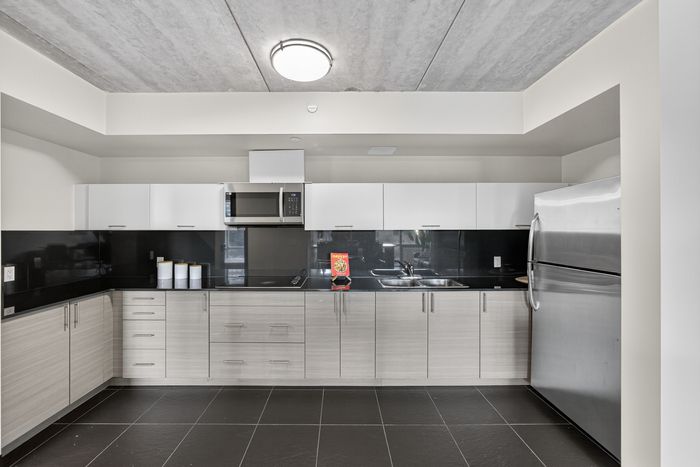 Sleek modern kitchen with stainless steel appliances, ample cabinetry, and elegant tile flooring.