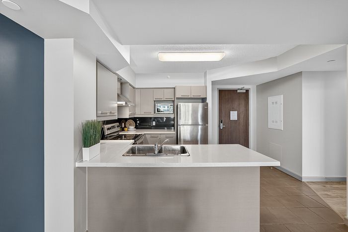 Modern kitchen with sleek stainless steel appliances, elegant cabinetry, and a spacious island in a chic apartment.