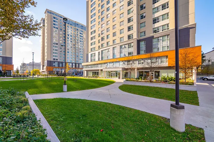 Modern apartment complex with a vibrant exterior and lush landscaped grounds.