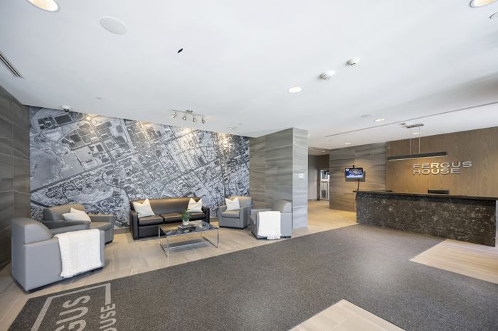 Modern apartment lobby at Fergus House featuring sleek seating, stylish decor, and an impressive city map mural.