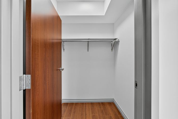 Elegant open wardrobe space with sleek wooden flooring, perfect for organizing your favorite outfits.