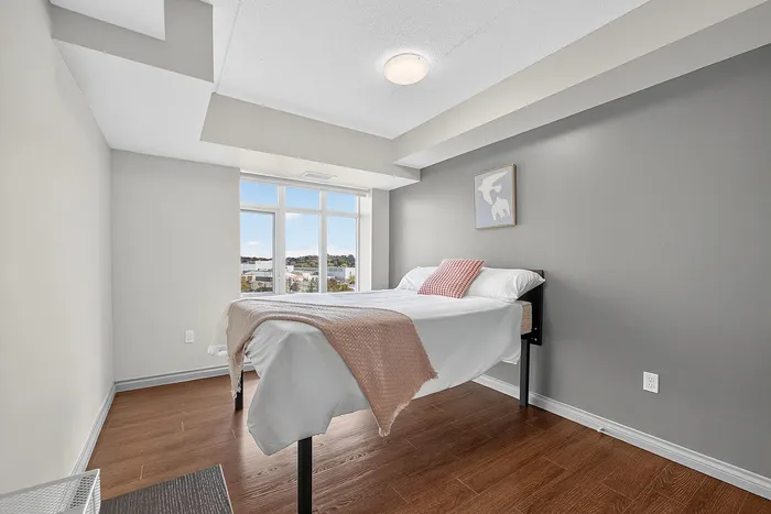 Bright, cozy bedroom with elegant modern design, featuring a large window with scenic views and comfortable bedding.