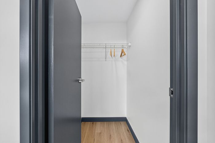 Modern walk-in closet with sleek shelving and elegant wooden hangers, offering ample storage space.