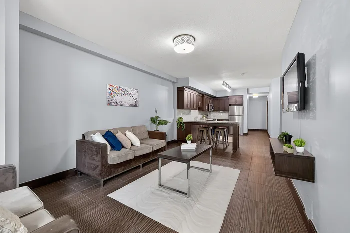 Modern open-concept living area featuring a chic living room with stylish furniture and a contemporary kitchen with sleek finishes.