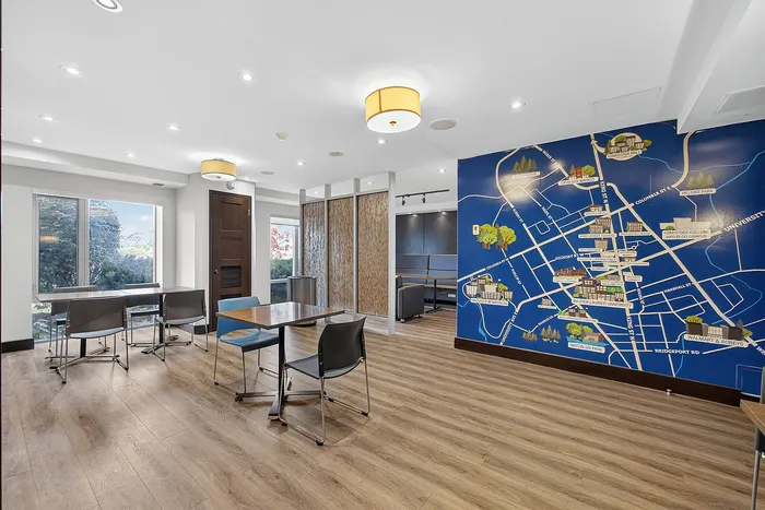 Elegant meeting room with modern decor, seamless wood flooring, and a vibrant map mural, offering a creative and professional workspace.