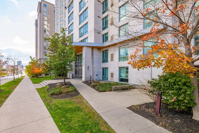 Inviting urban apartment exterior with modern architecture, surrounded by vibrant autumn foliage and a neatly maintained walkway.