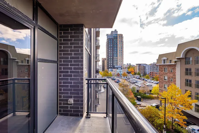 Modern city-view balcony with sleek brick design and vibrant autumn foliage, offering a stylish urban outdoor oasis.