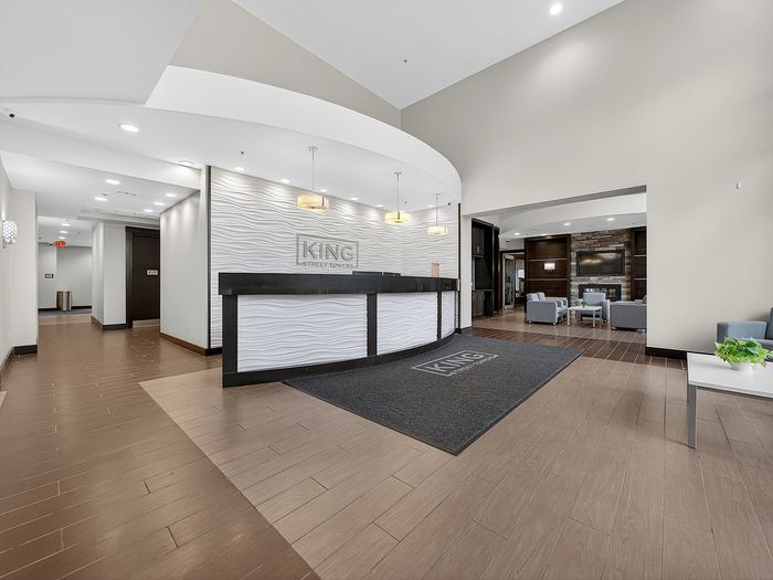 Elegant lobby area with modern design, featuring a stylish reception desk, chic lighting, and a cozy seating area with a fireplace.