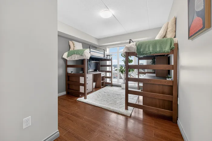 Bright bedroom with stylish loft beds and ample natural light, perfect for maximizing space and comfort.