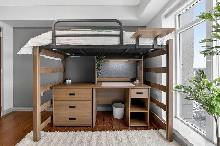 Chic lofted bed design with integrated desk space, accentuated by natural light and elegant wood finishes, ideal for maximizing small apartment living.